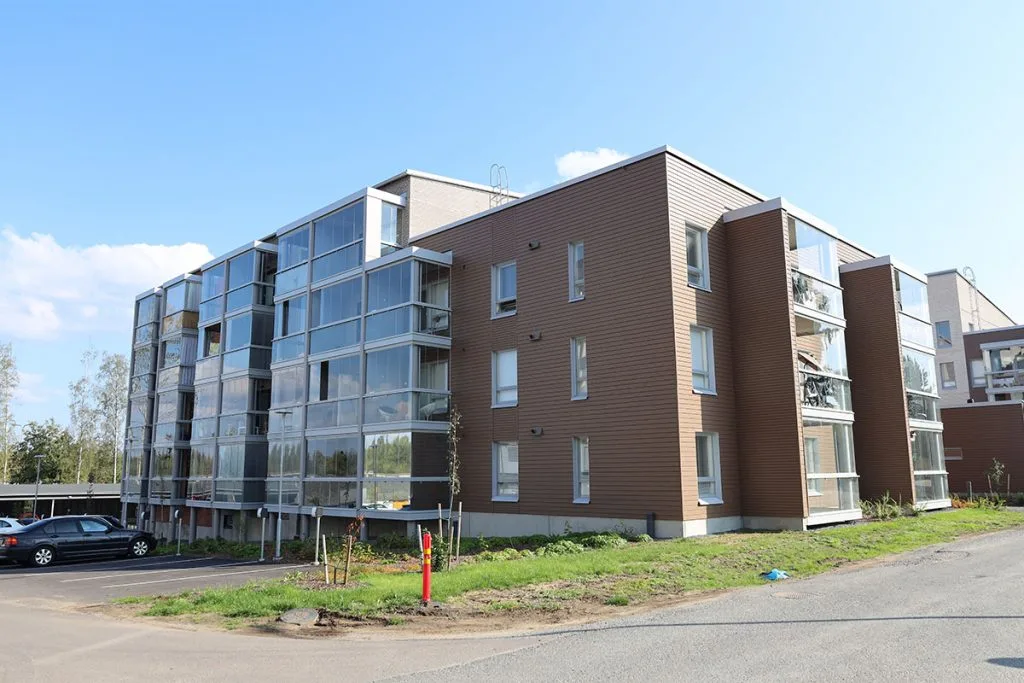 Kuvassa kerrostalo, johon on asennettu ilmalämpöpumppu viilentämään.