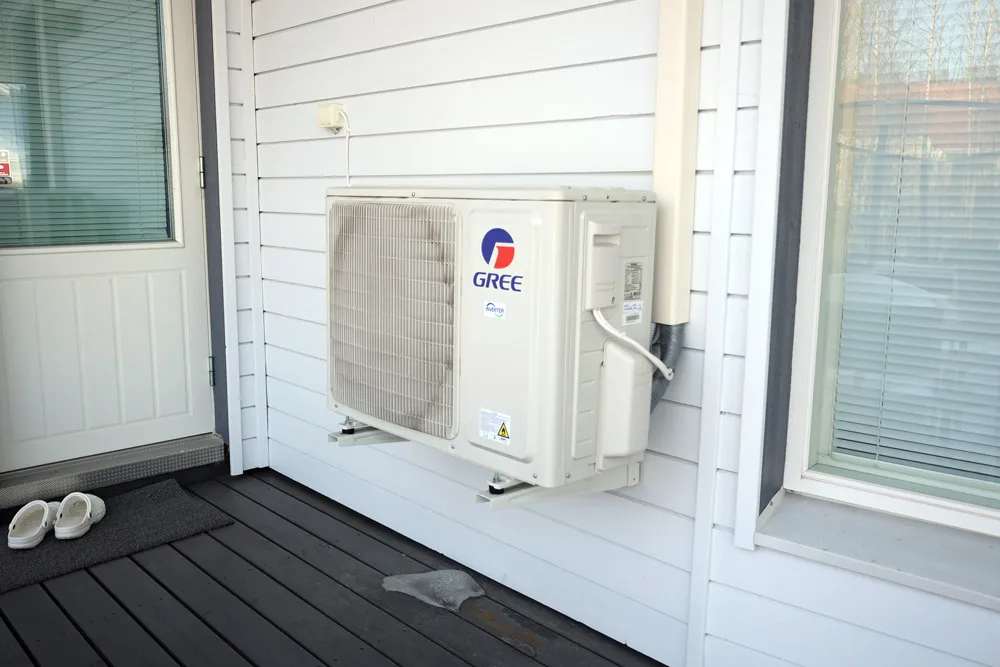 GREE:n ilmalämpöpumppu seinäasennettuna omakotitalon takapihalle.