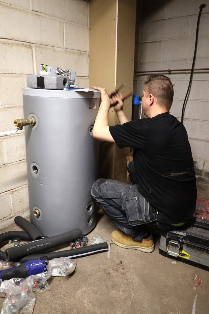 Mies asentaa puskurivaraajaa teknisessä tilassa.