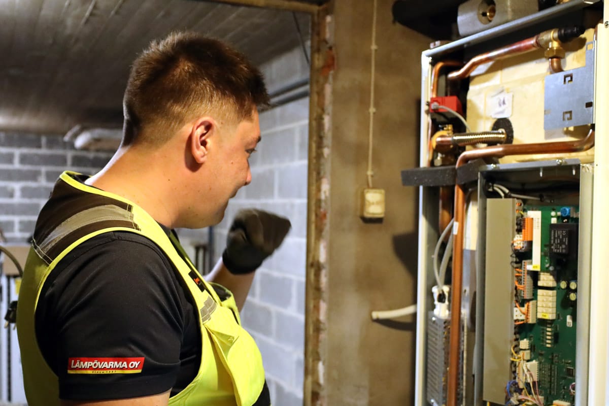 Lämpövarma Oy:n asentaja huoltamassa maalämpöpumppua
